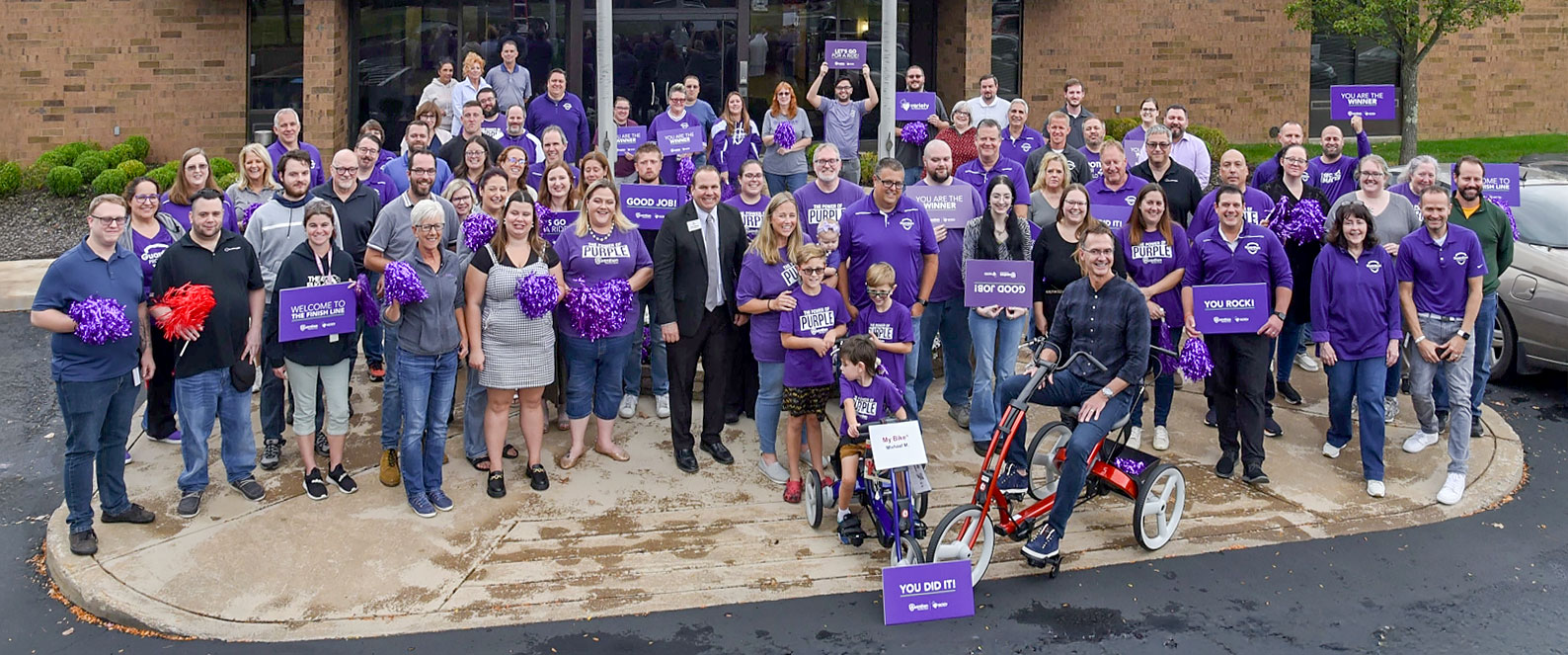 Group photo of Guardian employees and Mackie family in front of Guardian headquarters